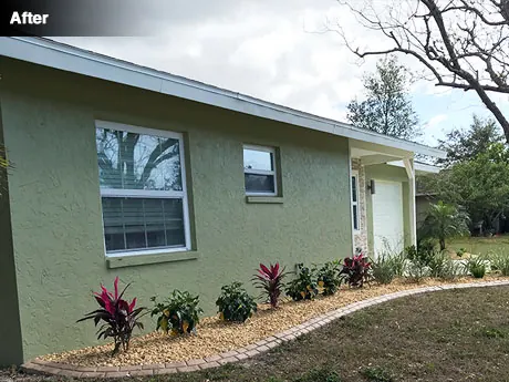 The front of the house after the cleanup, with new planting and river rock